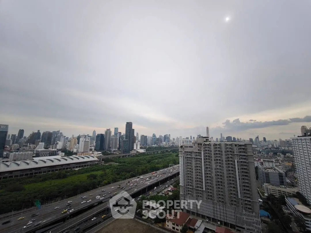 Stunning cityscape view from high-rise building with lush greenery and skyline.