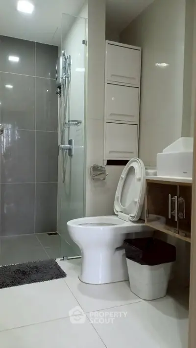 Modern bathroom with sleek design, featuring a glass shower and contemporary fixtures.