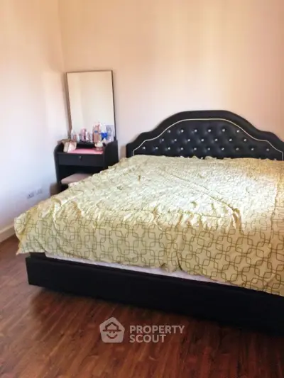 Cozy bedroom with elegant bed and wooden flooring, perfect for relaxation.
