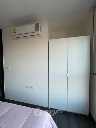 Modern bedroom with air conditioning and sleek wardrobe in a stylish apartment.