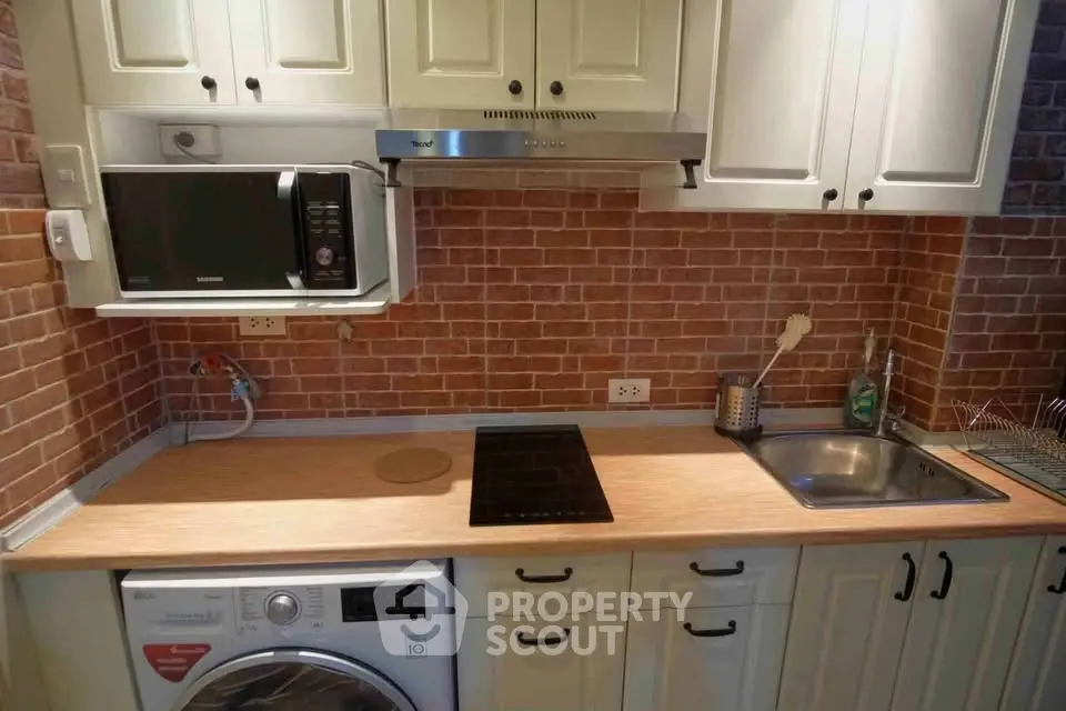 Charming kitchen with brick backsplash, modern appliances, and wooden countertops.