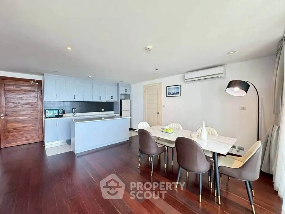 Spacious modern kitchen and dining area with sleek design and wooden flooring.
