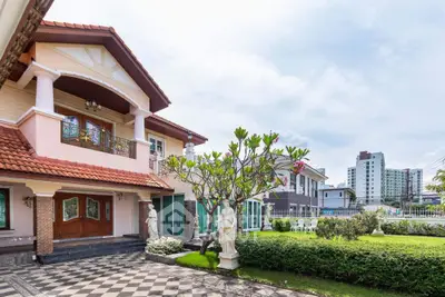 Elegant suburban house with lush garden and classic statues, offering serene residential living.