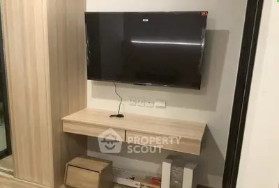 Modern living room with wall-mounted TV and sleek wooden console.