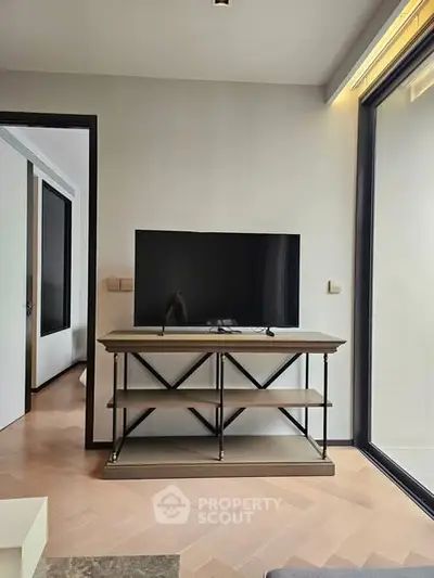 Modern living room with sleek TV stand and large window, showcasing contemporary interior design.