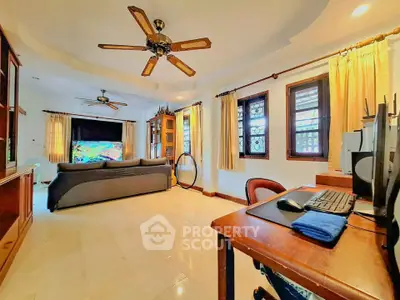 Spacious living room with ceiling fans, large windows, and cozy seating area for relaxation.