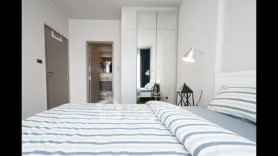 Modern bedroom with striped bedding and mirrored wardrobe