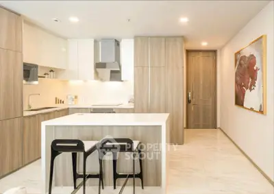 Modern kitchen with sleek design, featuring an island and stylish bar stools, perfect for contemporary living.