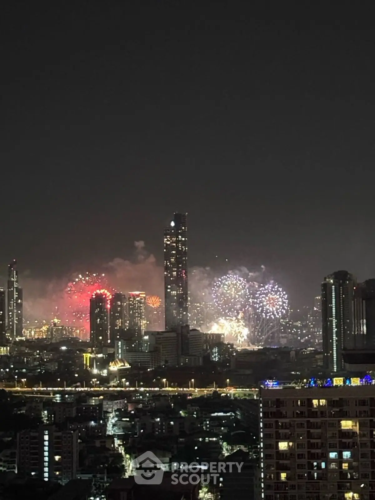 Stunning city skyline view with vibrant fireworks lighting up the night sky, perfect for urban living enthusiasts.