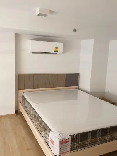 Modern bedroom with air conditioning and stylish bed frame in a cozy apartment.