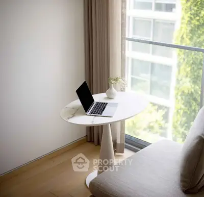 Modern minimalist living room with sleek furniture and large window view.
