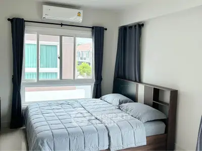 Modern bedroom with large window and stylish curtains in a contemporary apartment.