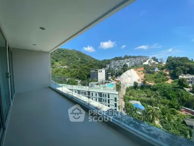 Spacious balcony with stunning mountain and city views in a modern apartment complex.