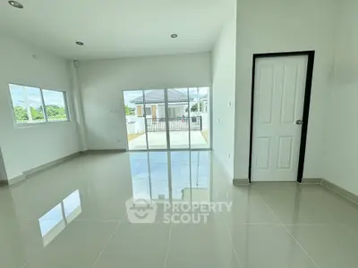 Spacious modern living room with glossy tiled floors and large windows offering natural light.