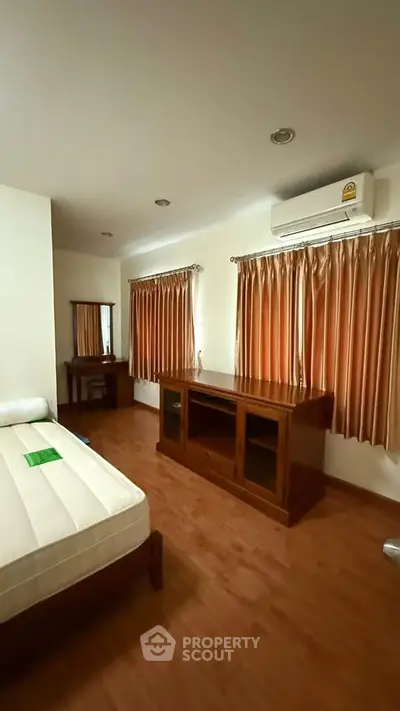 Spacious bedroom with wooden furniture and natural light