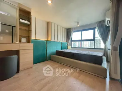 Modern bedroom with large window and city view, featuring stylish decor and ample natural light.