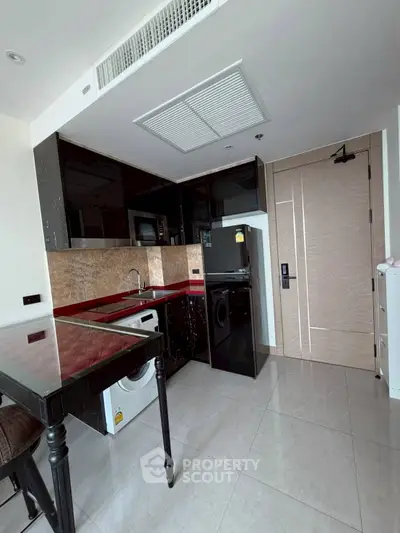 Modern kitchen with sleek black cabinets and built-in appliances