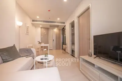 Modern living room with cozy seating and dining area in open layout apartment.