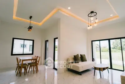 Modern living room with stylish lighting and large windows overlooking a garden view.