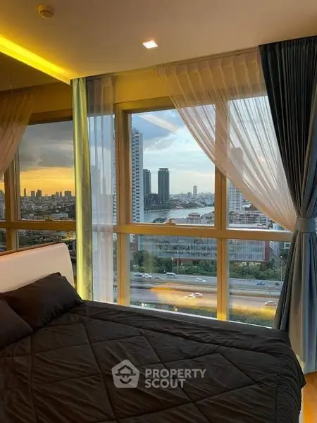 Luxurious bedroom with stunning cityscape and river view from large windows.