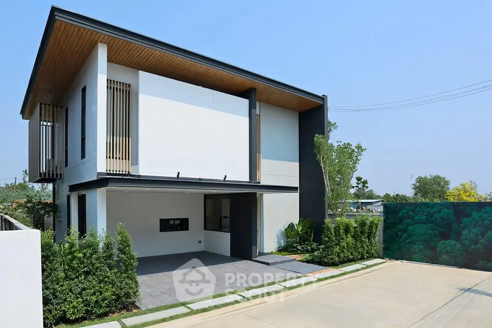Modern two-story house with sleek design and spacious driveway in a serene neighborhood.