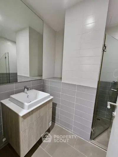 Modern bathroom with sleek vanity and glass shower enclosure