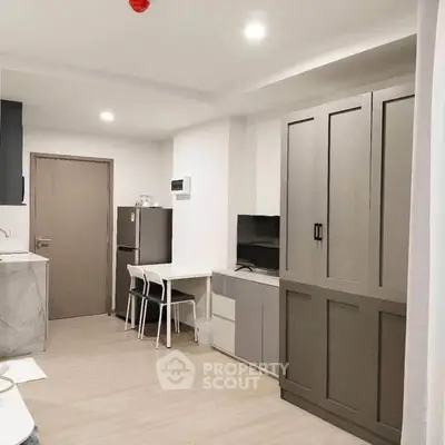 Modern studio apartment with sleek kitchen and cozy living area, perfect for urban living.