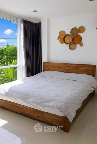 Bright and airy bedroom with large window and stylish decor