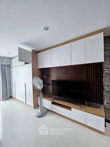 Modern living room with sleek TV unit and stylish fan