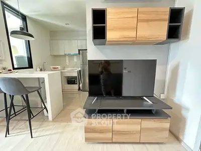 Modern open-layout living room with stylish kitchen and sleek TV setup