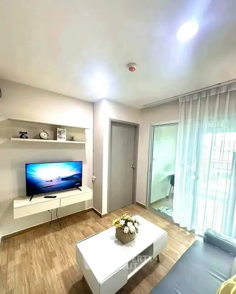 Modern living room with TV, cozy sofa, and elegant decor in bright apartment.