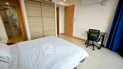 Spacious bedroom with modern design, featuring a large bed, built-in wardrobe, and a study desk.
