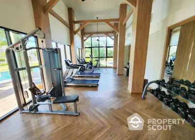 Luxurious gym with modern equipment and pool view in upscale property