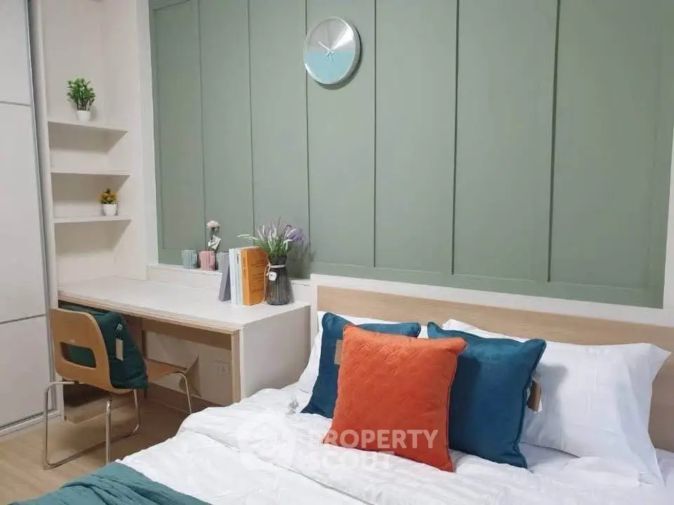 Modern bedroom with stylish decor and workspace, featuring a cozy bed and elegant wall paneling.