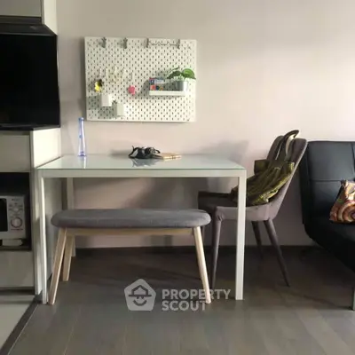 Modern living space with stylish furniture and decor, featuring a sleek glass table and comfortable seating.