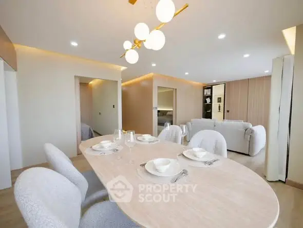 Elegant modern dining area with stylish lighting and cozy seating in a spacious open-plan living room.