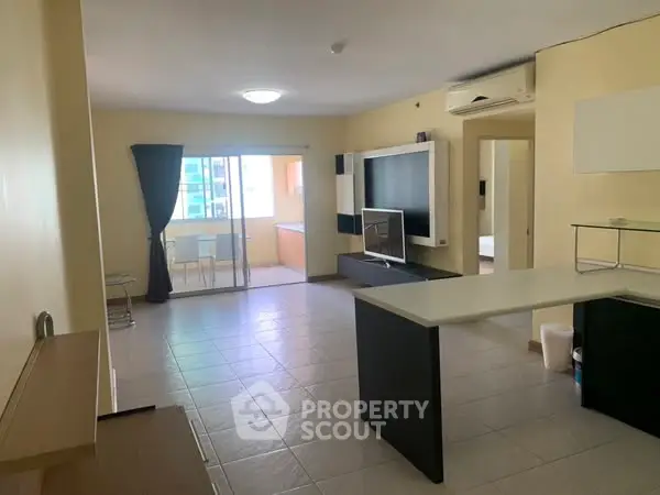 Spacious open-plan living room with modern furnishings and balcony access.