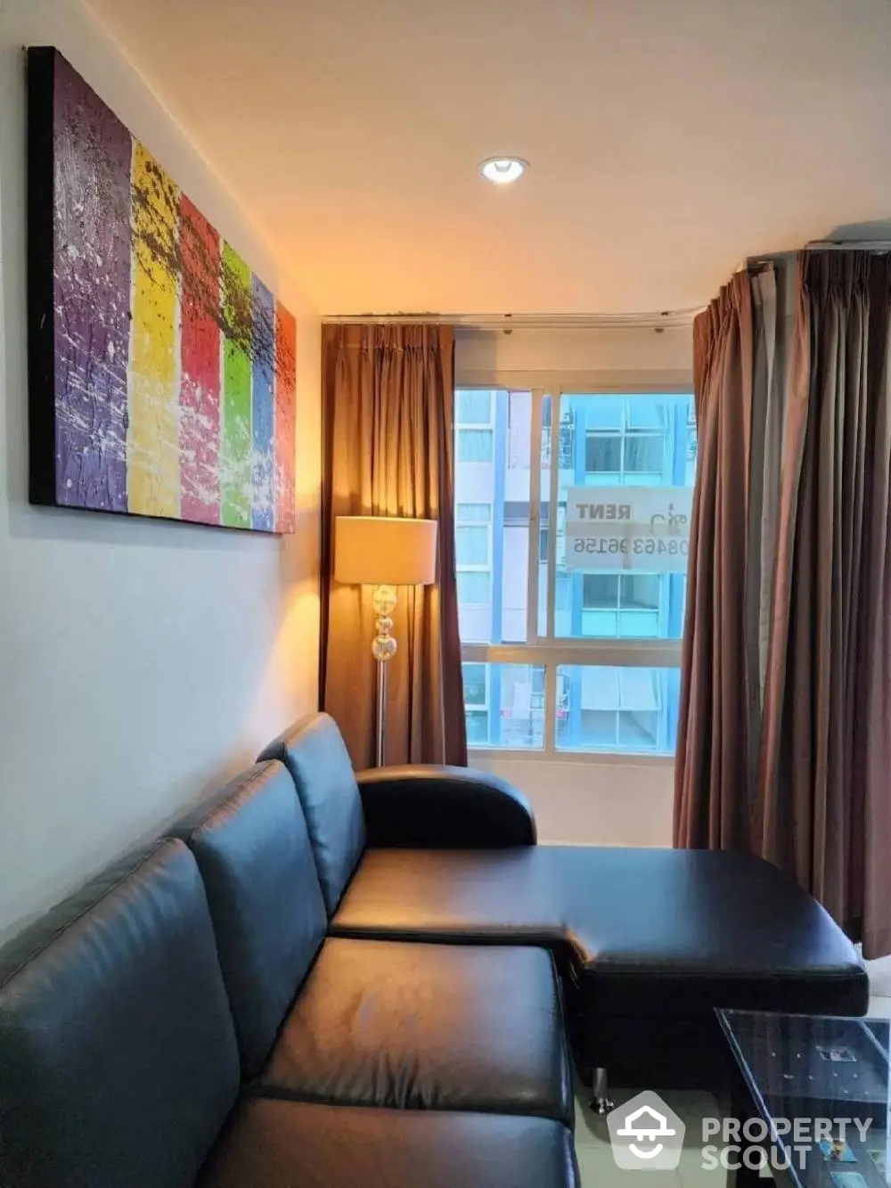 Cozy living room with modern leather sofa, vibrant wall art, and warm lighting, perfect for relaxation and entertaining guests.