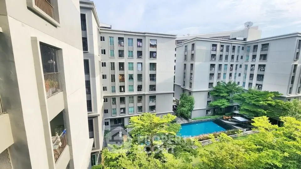 Modern apartment complex with lush greenery and inviting pool view