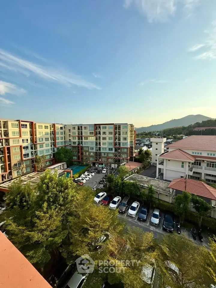 Stunning aerial view of modern apartment complex with lush greenery and ample parking, perfect for urban living.
