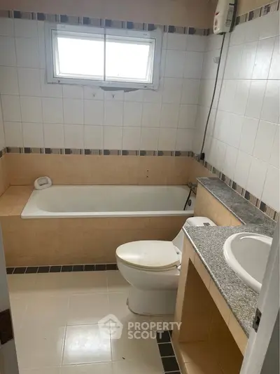 Spacious bathroom with bathtub and modern fixtures, ideal for relaxation and comfort.