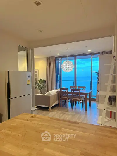 Stunning open-layout living room with ocean view, modern furniture, and elegant lighting.