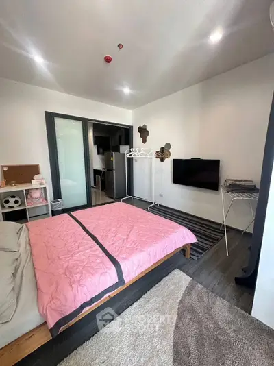 Modern bedroom with stylish decor and wall-mounted TV in a cozy apartment.