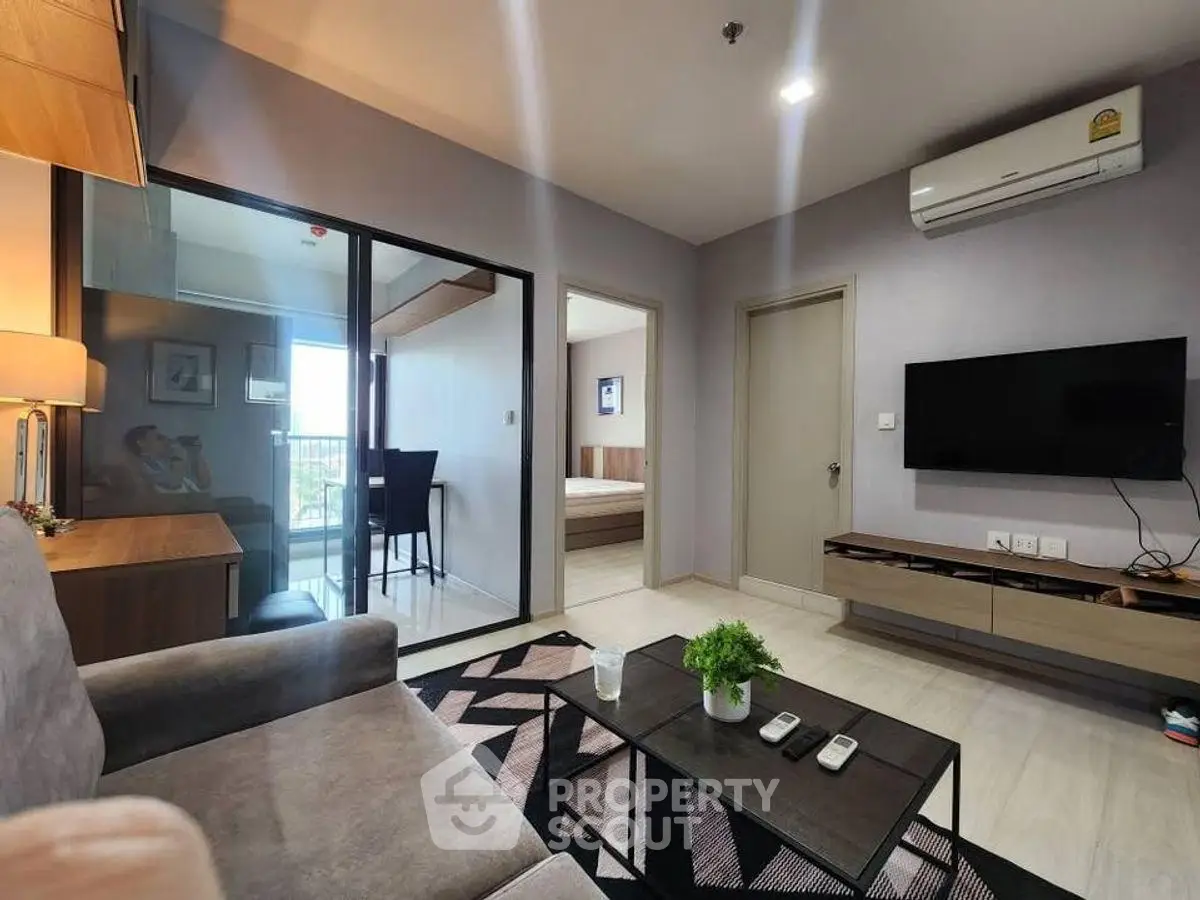 Modern living room with sleek furniture and balcony view, perfect for urban living.