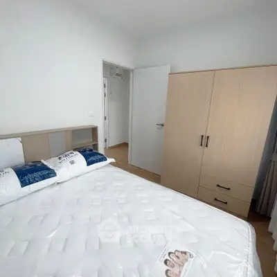 Modern bedroom with minimalist design, featuring a comfortable bed and sleek wardrobe.