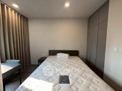 Modern bedroom with sleek design, featuring a comfortable bed and ample storage space.
