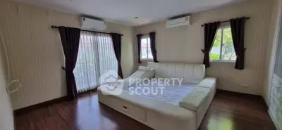 Spacious bedroom with modern white bed and large windows for natural light