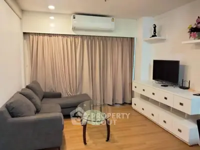 Modern living room with cozy gray sofa and glass coffee table