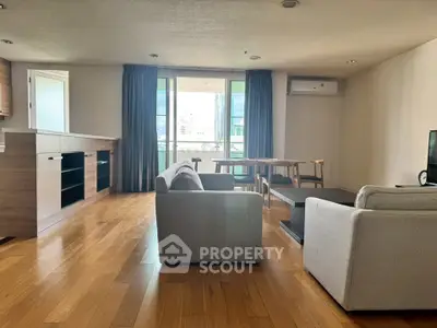 Spacious modern living room with wooden flooring and open kitchen layout.