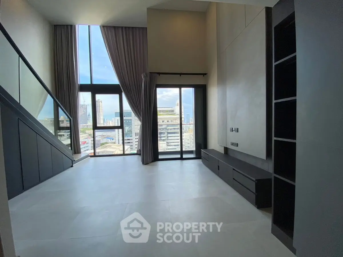 Spacious modern living room with floor-to-ceiling windows and city view